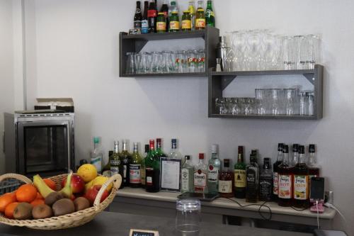 a counter with a basket of fruit and bottles of alcohol at The Originals City - Hôtel Saint-Martial, Limoges Centre in Limoges