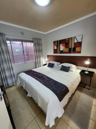 a bedroom with a large bed and a window at 80 Kendal Self-Catering Guest House in Bellville