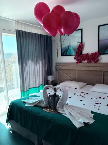 a bedroom with two swans with balloons on a bed at Hotel Carre Noir in Porto-Vecchio