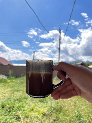 a person is holding a cup of coffee at Mountain View in Kochkor