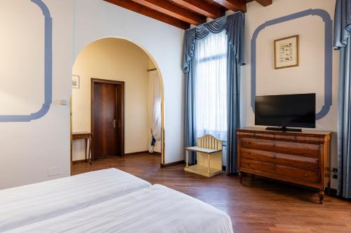 a bedroom with a bed and a tv on a dresser at Hotel Colombina in Venice