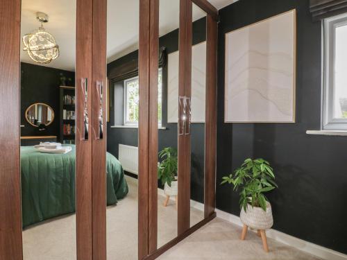a room with sliding glass doors with a green bed at The Active Recovery Retreat in Stone