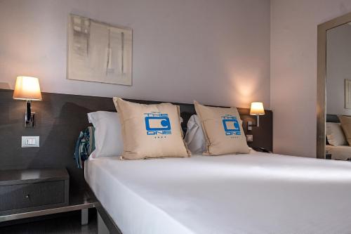 a bed in a room with two pillows on it at The One Hotel - Designed for Adults - Pet lovers in Riccione