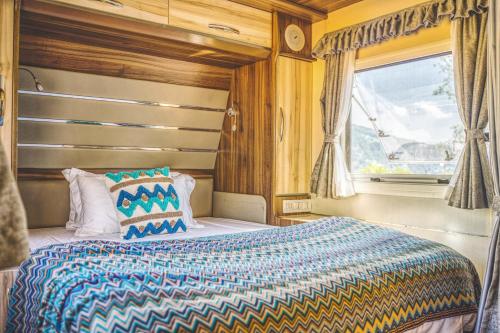 a bedroom with a bed and a window at Shanyin Xijiang Rustic Luxury Resort Hotel in Bailian