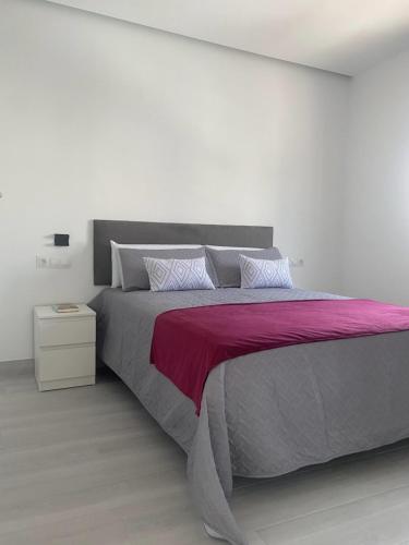 a bedroom with a large bed with a pink blanket at LEON 38 Apartments Private Parking - EaW Homes in Estepona