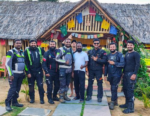 a group of men standing in front of a building at Om Shanti Om Home Stay & Cafe Hampi in Hampi