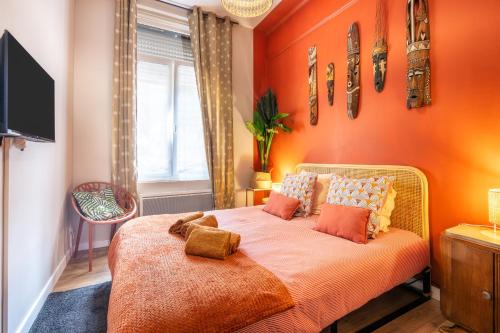 - une chambre orange avec un lit aux murs orange dans l'établissement Sable et savane Proche de la plage, à Dunkerque