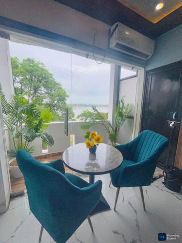 a dining room with a table and chairs and a window at The Ghat House in Varanasi