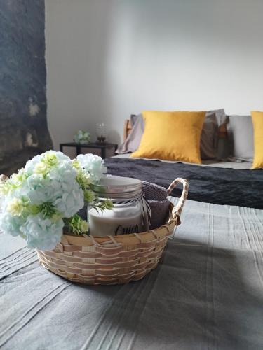 a basket with flowers in it on a bed at Bragada Stonehouse in São Roque do Pico