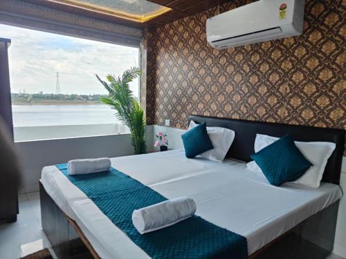 a bedroom with a large white bed with a window at The Ghat House in Varanasi