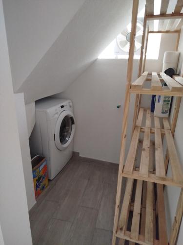 a laundry room with a ladder and a washing machine at Bragada Stonehouse in São Roque do Pico