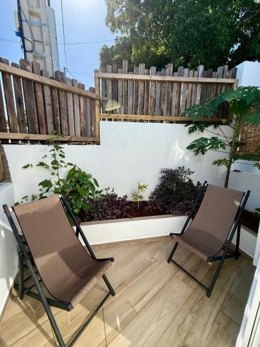 two chairs sitting on a patio with a fence at La Kaz Banian in Saint-Pierre