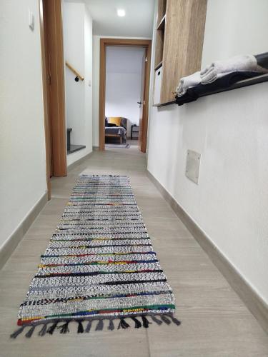 a hallway with a rug on the floor at Bragada Stonehouse in São Roque do Pico