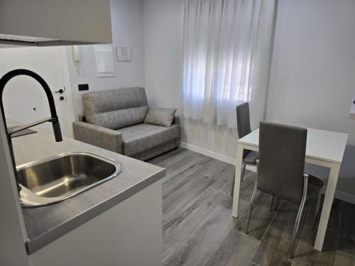 a kitchen and living room with a sink and a couch at Apartamentos Turísticos AIRES DE LA VERA in Jaraiz de la Vera