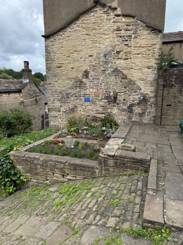 a brick building with a garden in front of it at No.18 Holmfirth in Holmfirth
