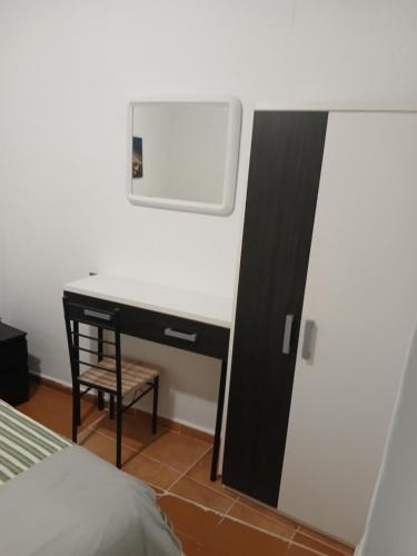 a bedroom with a desk with a mirror and a bed at Casita esquiladores in Cuenca