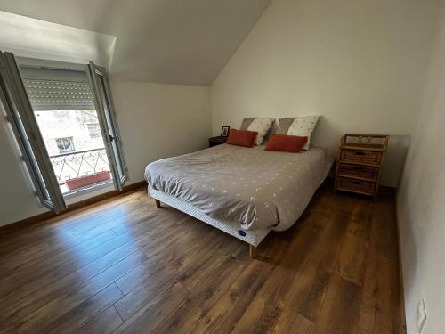 a bedroom with a bed and a wooden floor at La Maison du Marinier in Crouzilles