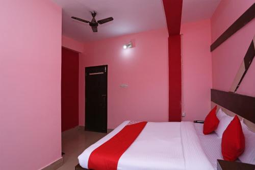 a pink bedroom with a bed and a ceiling fan at Hotel O Guddu Residency in Bārang