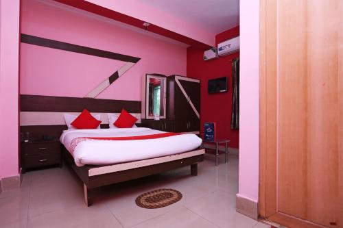 a bedroom with a large bed with red pillows at Hotel O Guddu Residency in Bārang