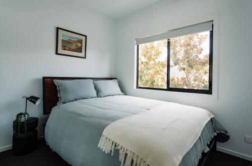 BooragulにあるBright & Modern Booragul Home for Familiesのベッドと窓のある白い寝室