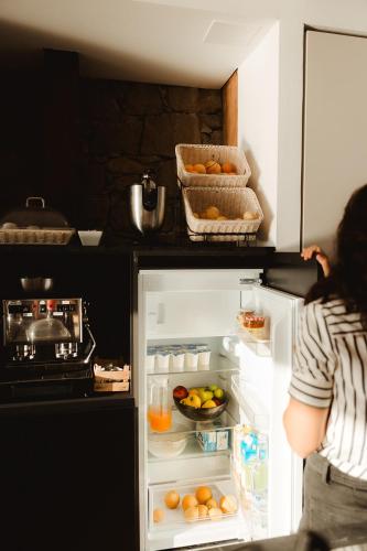 a person is looking inside of an open refrigerator at Casale Santa Rosalia Charme Villas and Rooms in San Mauro Cilento