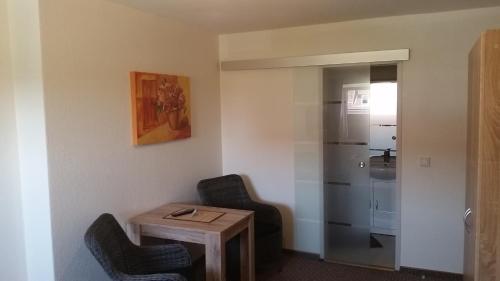 a room with two chairs and a table and a refrigerator at Hotel Deutsches Haus Francop in Hamburg