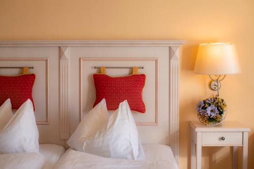 a bedroom with a bed with red pillows on it at Thermenhotel Vier Jahreszeiten in Lutzmannsburg