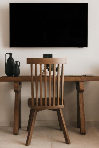 a wooden chair sitting in front of a television at Castor & Pollux in Kotrónion