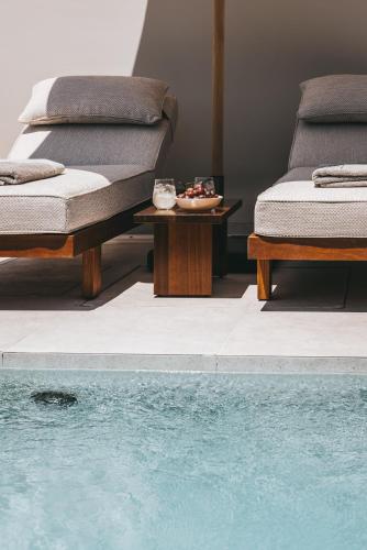 two beds and a table next to a swimming pool at Castor & Pollux in Kotrónion