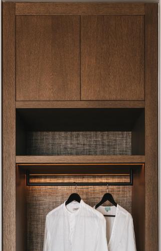 two white shirts are hanging on a wooden cabinet at Castor & Pollux in Kotrónion