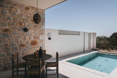 a room with a table and a swimming pool at Castor & Pollux in Kotrónion