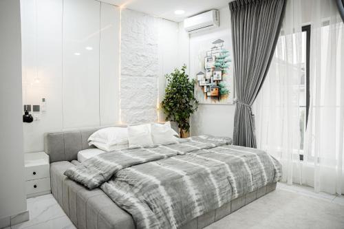 a bedroom with a bed with a plaid blanket on it at Brand New 2bed flat close to the beach with 2 balconies in Lekki