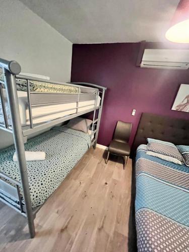 Cette chambre dispose de lits superposés avec 2 lits superposés et une chaise. dans l'établissement Pavillons 6 personnes 15 minutes Disney, à Lagny-sur-Marne