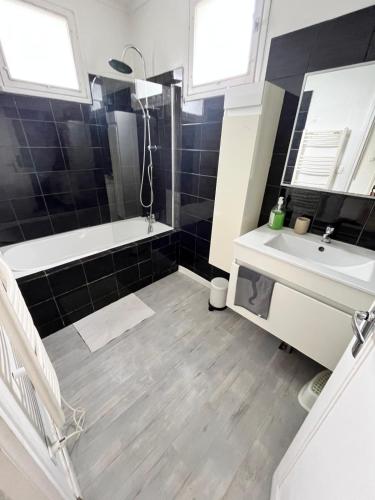 La salle de bains est pourvue d'une baignoire, d'un lavabo et d'une baignoire. dans l'établissement Pavillons 6 personnes 15 minutes Disney, à Lagny-sur-Marne