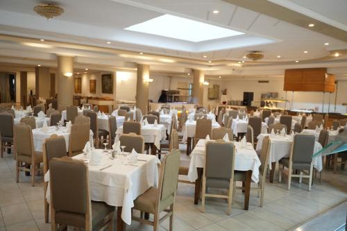 a dining room with white tables and chairs at Golf Residence- Families and Couples Only in Hammam Sousse