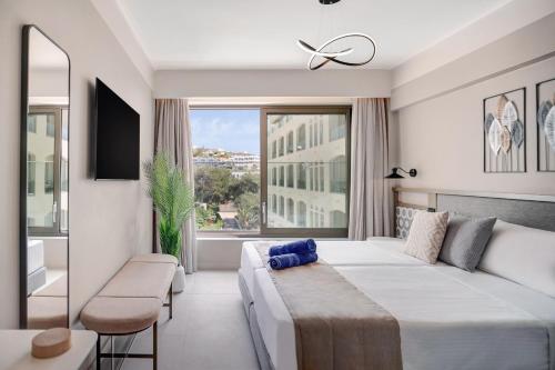 a bedroom with a large bed and a large window at Creta Star Hotel - Adults Only in Skaleta