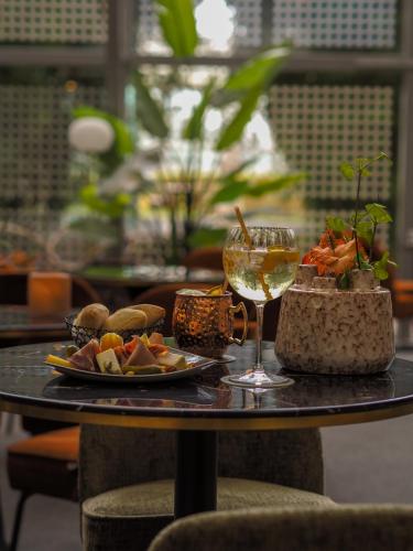 a table with a plate of food and a glass of wine at Van der Valk Hotel Paris CDG Airport in Roissy-en-France