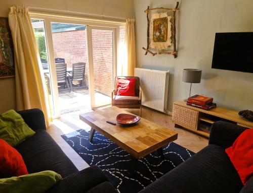 een woonkamer met een bank en een salontafel bij Holiday house Zeelust - 2 km from the beach in Noordwijkerhout