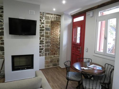 a living room with a table and a fireplace at Rodonas-Apartments in Volissos