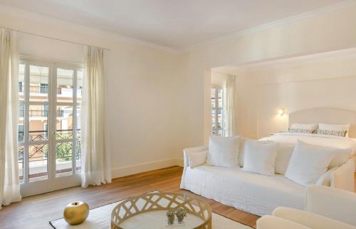 a white bedroom with a bed and a couch at Etoile Luxury Suites in Argostoli