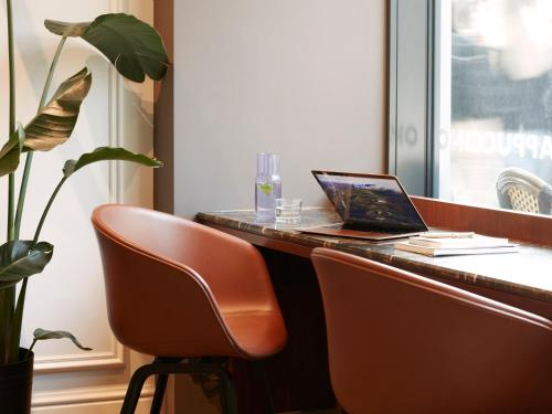 a desk with a laptop sitting on top of it at Numa Berlin Savi in Berlin