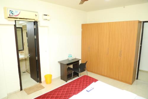 a room with a desk and a wooden cabinet at Shastik Residency in Oragadam