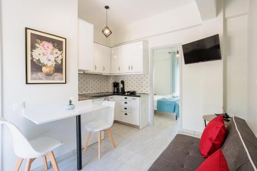 a kitchen and living room with a table and chairs at Seaview Tranquility - Elegant Escapes by the Shore in Ayía Kiriakí