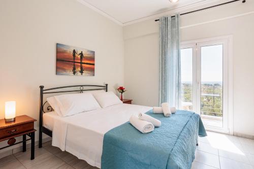 a bedroom with a bed and a large window at Seaview Tranquility - Elegant Escapes by the Shore in Ayía Kiriakí