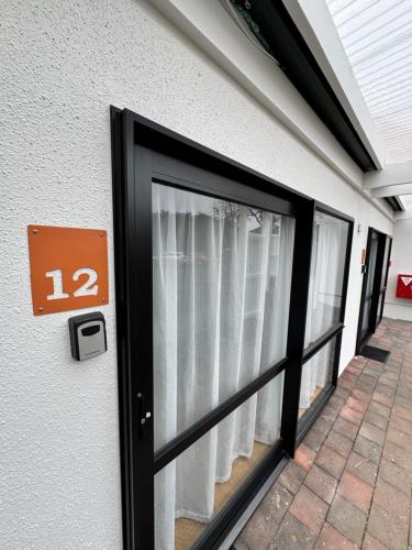 a door with a window with white curtains at Mt Wellington Motel in Auckland