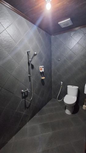 a bathroom with a toilet and a shower at Villa Rosewood in Paragajen