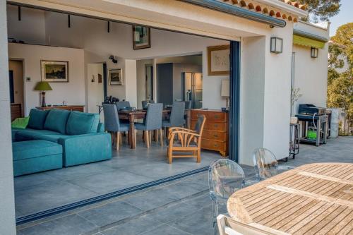 a patio with a couch and a table and chairs at St Aygulf - Villa Marinade 280 m de la mer in Fréjus