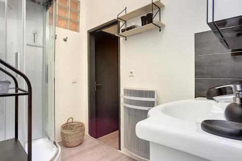 a bathroom with a white sink and a shower at Cours Massena on Marché Provencal in Antibes