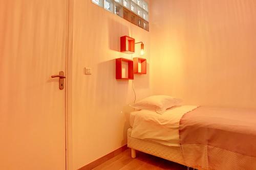 a bedroom with a bed and a door with lights at Cours Massena on Marché Provencal in Antibes