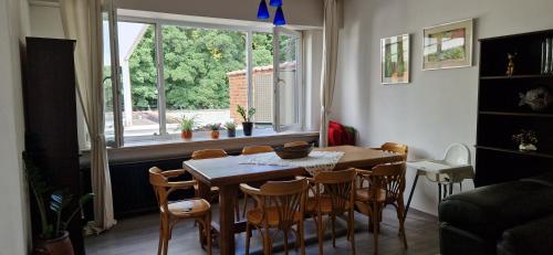 a dining room with a table and chairs and a window at Apartamento de la grotte in Brussels